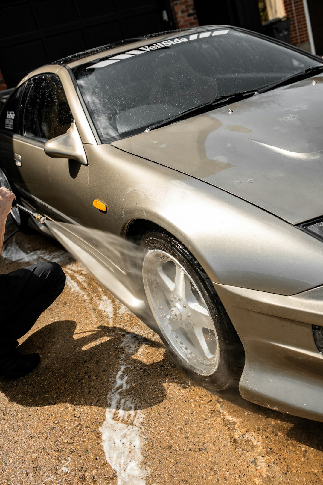 person washing car with sponge