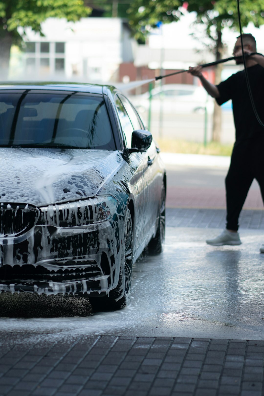 person washing car with sponge